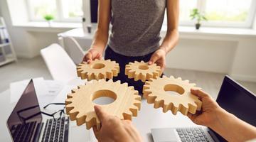 CIRN Session 5 header stock People holdiing wooden gear simpolising cooperation